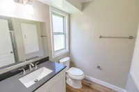 Bright and modern bathroom featuring a sleek vanity, natural light from a large window, and elegant fixtures.