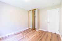 Bright room with hardwood floors and a spacious mirrored closet offering ample storage.