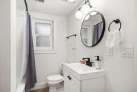 Elegant bathroom design featuring sleek fixtures, round mirrors, and a bright, modern aesthetic with stylish lighting.