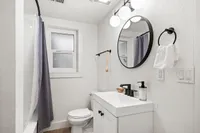 Elegant bathroom design featuring sleek fixtures, round mirrors, and a bright, modern aesthetic with stylish lighting.