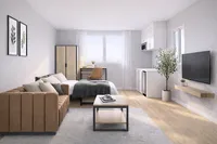 Modern studio apartment with elegant decor, featuring a cozy bed, stylish sofa, and compact kitchen area in a bright, natural light-filled space.