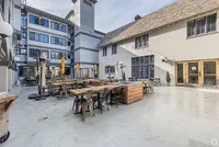 Charming courtyard with outdoor seating, string lights, and historic architecture, perfect for relaxing and social gatherings.