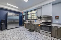 Modern kitchen with sleek stainless steel appliances, elegant cabinetry, and stylish patterned flooring.