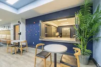 Modern seating area with natural light, sleek furniture, and vibrant decor, perfect for relaxation and socializing.