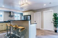 Elegant modern kitchen with sleek countertops, stylish bar stools, and stainless steel appliances, perfect for entertaining.