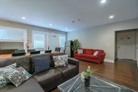 Inviting modern living room with cozy seating, stylish decor, and open dining area on elegant wooden floors.