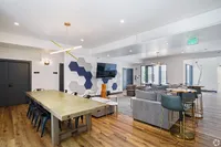 Modern communal living space with stylish seating, a large dining table, and contemporary decor exuding elegance and comfort.