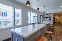 Bright, modern kitchen with sleek marble countertops, stylish pendant lighting, and bar seating.