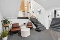 Elegant and cozy lobby area featuring modern seating, stylish staircase, and warm lighting accents.