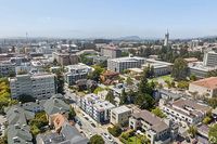 Scenic aerial view of a vibrant urban neighborhood with modern architecture, lush greenery, and a dynamic skyline.
