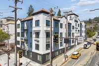 Charming urban apartment building with modern architecture, featuring elegant balconies and located at a bustling city intersection.