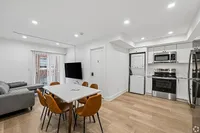 Modern apartment interior featuring an open-plan living area with a sleek kitchen, cozy gray sofa, stylish dining table with brown chairs, and wall-mounted TV. Bright natural light floods through large sliding doors, enhancing the fresh and inviting atmosphere.
