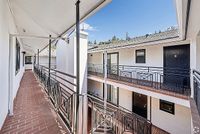 Charming apartment exterior with elegant railings, brick walkway, and scenic views, offering a welcoming atmosphere.