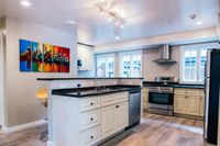 Bright modern kitchen with sleek cabinets, granite countertops, and stainless-steel appliances.