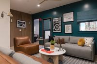 Contemporary living room with plush seating, teal accent wall, and stylish decor.