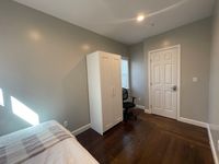 Inviting small bedroom with modern decor including a wardrobe, chair, and window with natural light.