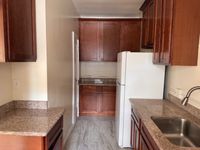 Inviting, modern kitchen with elegant wooden cabinetry, sleek granite countertops, and a spacious layout maximizing functionality.