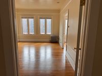 Bright and airy room with large windows and sleek wooden flooring, ideal for a cozy living space.
