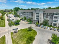 Charming apartment complex with modern architecture, ample parking, and lush greenery in a serene neighborhood setting.