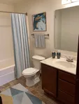Charming bathroom with modern design featuring elegant wooden cabinetry, sleek fixtures, and artistic wall decor. Bright and inviting space perfect for relaxation.