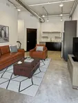Chic industrial-style apartment with leather seating, modern kitchen, and stylish decor, perfect for urban living.