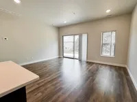 Bright and airy living room with sleek wood flooring and large windows offering natural light.