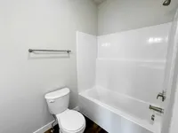 Contemporary bathroom with sleek white bathtub, modern fixtures, and elegant design.