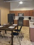 Modern kitchen with contemporary cabinetry, sleek black appliances, and a cozy dining area for four.