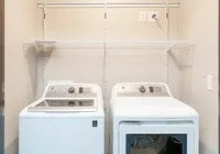 Modern laundry area with sleek washer and dryer, complemented by convenient shelving for organized storage.
