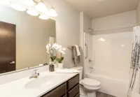 Elegant bathroom with modern fixtures, a spacious vanity, and decorative orchid accents.
