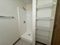 Modern bathroom with sleek shower and convenient built-in wire shelving for ample storage.