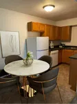 Charming kitchen and dining area featuring elegant marble table, modern appliances, and warm wooden cabinetry for a cozy living space.
