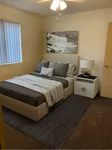 Inviting bedroom featuring a plush bed with stylish pillows, elegant bedside table, and soothing neutral tones, perfect for relaxation.