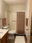 Cozy bathroom featuring a sleek bathtub with a patterned curtain, modern fixtures, and a stylish vanity.