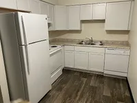 Modern kitchen with sleek white cabinetry, granite countertops, and stainless steel appliances.