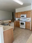 Inviting kitchen with modern appliances, ample wood cabinetry, and sleek countertops, perfect for culinary enthusiasts.