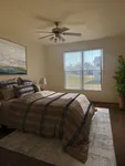 Inviting bedroom with a large window, cozy bedding, and modern decor enhanced by natural light.