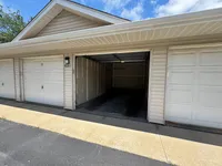 Inviting and spacious garage with wide-open doors, perfect for vehicle storage or a creative workspace.