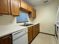 Inviting kitchen with warm wooden cabinets, sleek countertops, and modern appliances, perfect for culinary creativity.