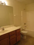 Inviting bathroom with a sleek vanity, modern lighting, and a pristine bathtub, ideal for relaxation.