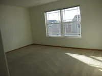 Bright and airy room with plush carpeting and expansive windows offering a scenic view, ideal for a serene living space.