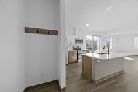 Bright and modern kitchen with sleek island, stainless steel appliances, and large windows offering natural light.