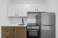 Modern kitchen with sleek stainless steel appliances, white cabinetry, and elegant black faucet, offering a contemporary and functional space.