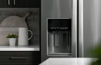 Sleek modern kitchen showcasing Whirlpool stainless steel refrigerator, elegant quartz countertop, and stylish backsplash with minimalist decor.