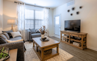 Modern, cozy living spaces with stylish décor, luxury flooring, and warm wood accents for a welcoming feel. Cozy living room with stylish wooden furniture, modern decor, and abundant natural light through large windows.