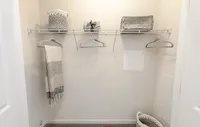 Spacious bedrooms featuring luxury carpeting, ample natural light, and spacious closets, creating a comfortable and stylish retreat. Inviting closet space with elegant storage baskets and cozy towels, offering functionality and style.