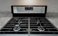 Gourmet-inspired kitchen featuring designer cabinetry, sleek granite countertops, and high-end stainless steel appliances. Sleek modern kitchen stovetop featuring a stainless steel range and four burners, perfect for culinary enthusiasts.
