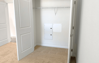 Spacious bedrooms featuring luxury carpeting, ample natural light, and spacious closets, creating a comfortable and stylish retreat. Bright and spacious closet with sleek white doors and built-in shelving, perfect for organized storage in a modern apartment.