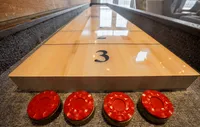 Our clubhouse offers a fun and vibrant space with a billiards table and a variety of games, perfect for relaxing and socializing with friends and neighbors. Inviting shuffleboard table with vivid red pucks, ideal for entertaining and relaxation in your stylish apartment.