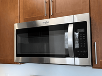 Gourmet-inspired kitchen featuring designer cabinetry, sleek granite countertops, and high-end stainless steel appliances. Modern kitchen featuring sleek stainless steel microwave and stove with rich wooden cabinets, exemplifying stylish functionality.